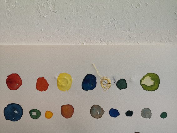 Prikker i ulike farver på papir, detalj av et bilde